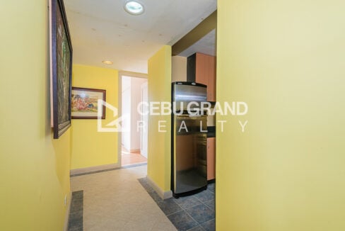 Hallway past the stainless two-door refrigerator and kitchen