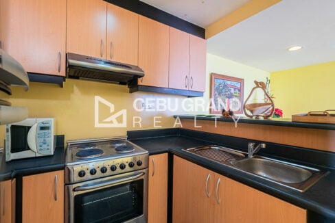 Kitchen with wood-tone cabinets, range hood, electric range with oven and sink