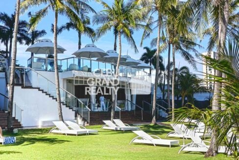 Beach club pavilion and lawn with sun loungers at Movenpick Residences