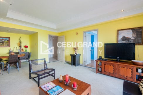 Living room toward the entry door, bedroom door and round dining table