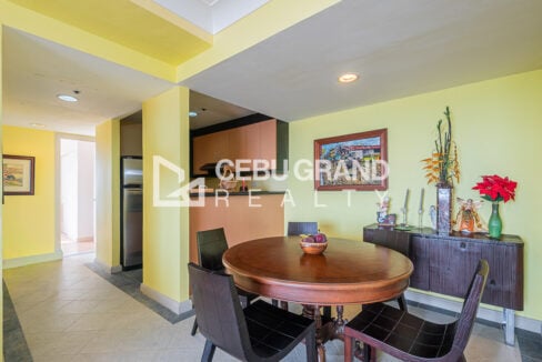 Dining area with round wood table, sideboard and the kitchen pass-through