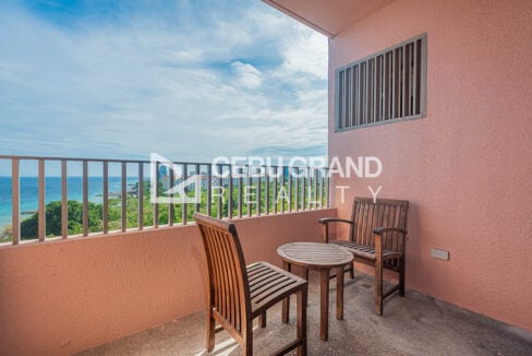 Balcony with wooden chairs and table overlooking the Mactan coastline