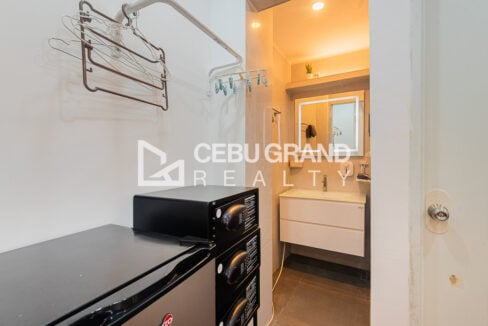 Guest room nook with a mini fridge, safes and a lit vanity