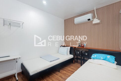 Twin guest room with in-room safes and a wall-mounted air conditioner