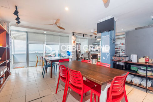 Dining hall with long tables and glass doors to the sea-view veranda