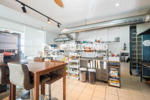 Restaurant-style kitchen with stainless counters and a bar table