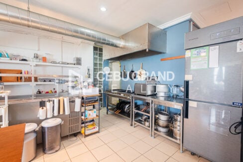 Commercial kitchen with range hood, cooking station and upright chiller