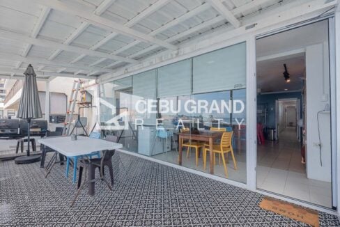 Veranda with a BBQ grill and glass wall into the dining hall