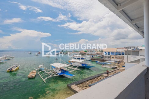 Seafront view of outrigger boats moored below the dive hotel in Buyong
