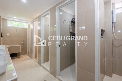 Row of tiled shower stalls in the shared bathroom
