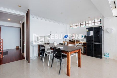 Dining area with kitchenette, black refrigerator and glass-block windows