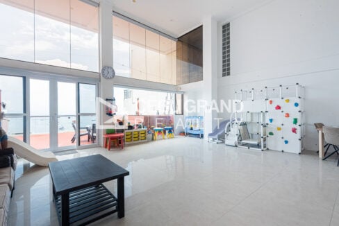 Bright lounge with play area and glass doors to the rooftop deck