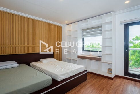 Guest room with slatted wood wall, built-in shelves and a balcony door