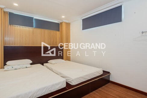 Guest room with platform beds and roller blinds on high windows