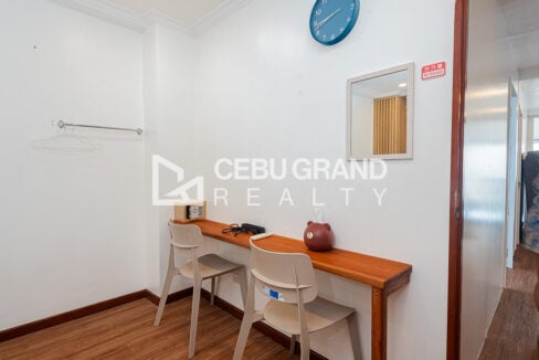 Desk counter with chairs, mirror and safe in a guest room