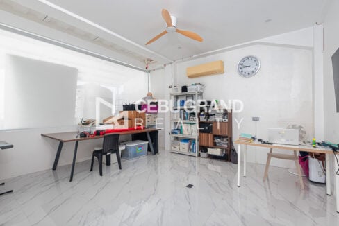 Ground-floor office with desks, shelving and a split-type air conditioner