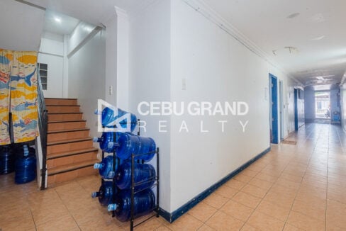 Staircase and hallway with a water dispenser rack on the ground floor
