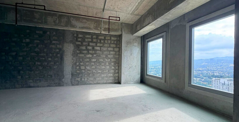 Two tall windows framing the hills above Lahug in a bare-shell office unit