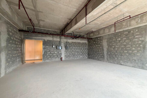 Office entrance with conduit drops, electrical boxes and red sprinkler piping overhead