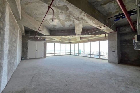 Coffered concrete ceiling over an open bare-shell floor beside the corner glazing