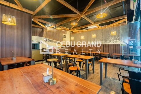 Restaurant for rent in Kasambagan with a timber-truss ceiling, rattan pendant lights and timber dining tables
