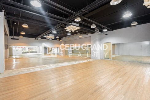 Open studio floor with full-wall mirrors and a second practice area at one end