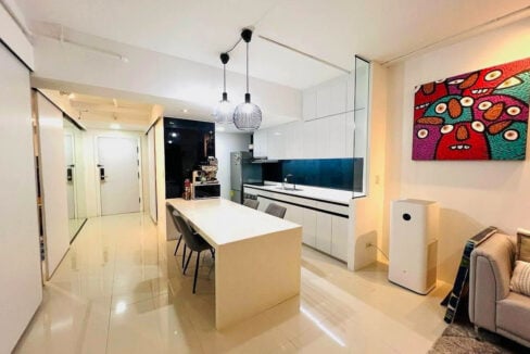 Kitchen and dining island under wire pendant lights, with the entry hall beyond