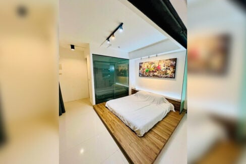 Master bedroom in the Cebu Business Park condo with a platform bed and lit headboard ledge