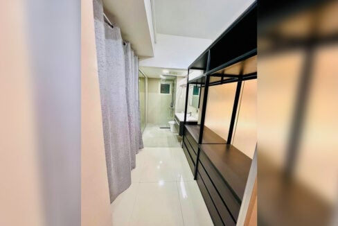Walk-through dressing area with an open black-metal wardrobe leading to the bathroom