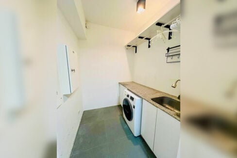 Laundry room with a front-load washer, granite counter and stainless sink
