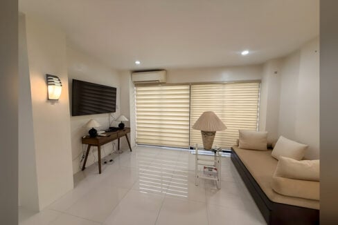 Living room with wall-mounted TV, wood console, split aircon and daybed sofa