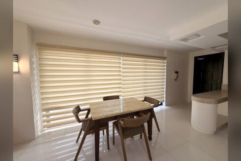 Dining area with marble-top table for four, zebra blinds and curved breakfast counter