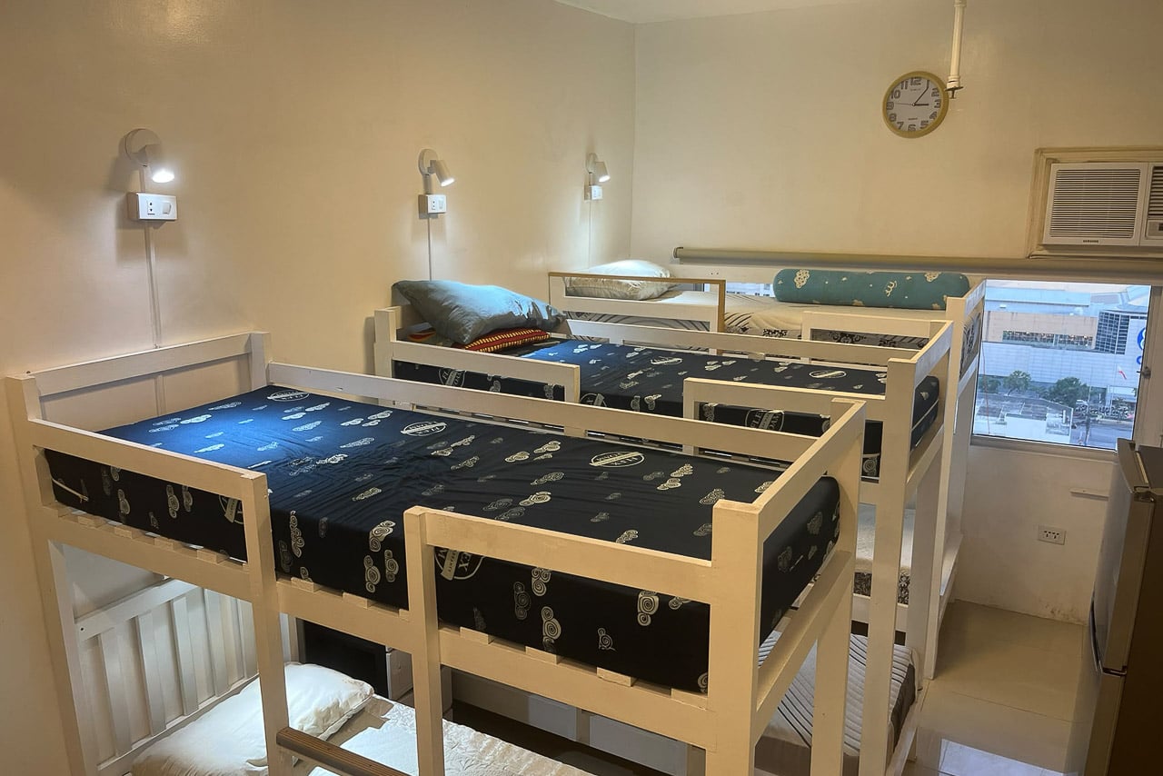 Furnished studio at San Marino Residences with white timber bunk beds and a reading light at each bed