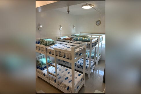 Bunk beds made up with blue-patterned sheets under the ceiling light