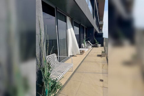Long terrace with slatted lounge chairs and planters in a 2BR corner condo for rent at The Reef, Mactan