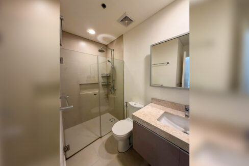 Bathroom with a glass shower enclosure, rain shower head and stone-look vanity