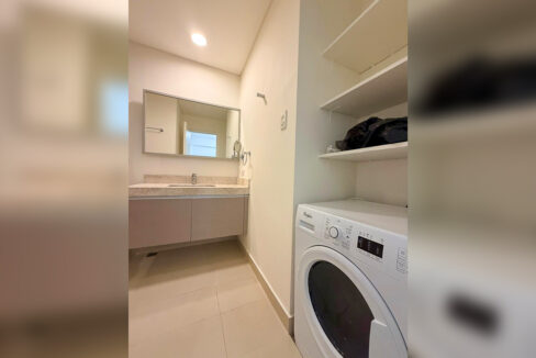 Laundry nook with a front-load washer, open shelves and a wall mirror