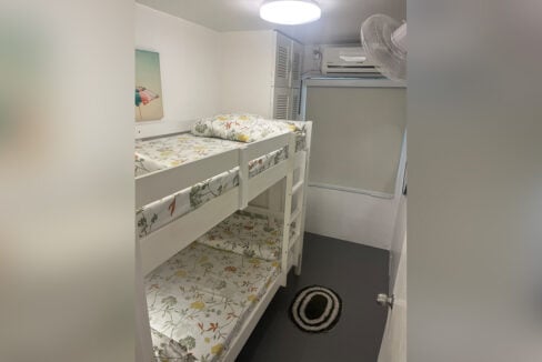 Second bedroom with a white bunk bed and split-type aircon
