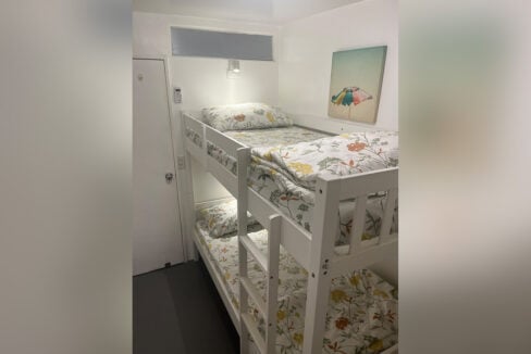 Bunk bed with floral bedding and a reading light by the door