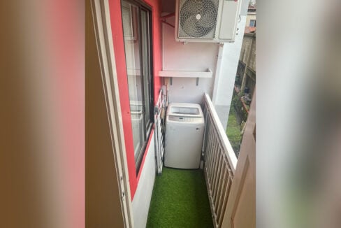 Service balcony with a top-load washing machine and drying rack