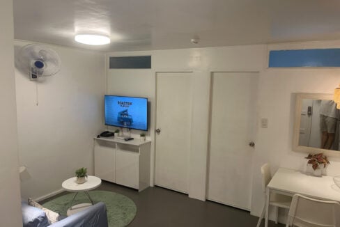 Wall-mounted TV, custom white console and dining nook in the living area