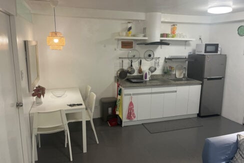 Kitchenette and dining table for two under a rattan pendant light