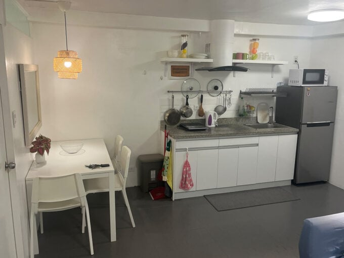 Kitchenette and dining table for two under a rattan pendant light