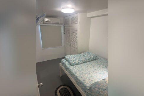 Bedroom with a double bed, split-type aircon and a custom louvered wardrobe