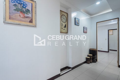 Hallway in the Banilad townhouse with framed prints and a wall clock