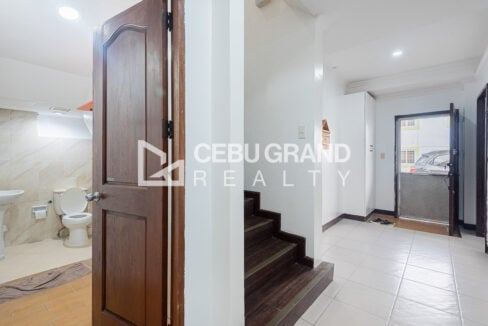 Ground-floor bathroom beside the dark wood staircase and the front door