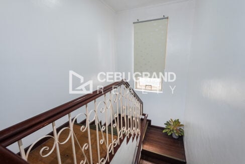 Stair landing with a roller-blind window and a potted plant