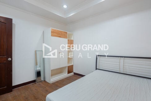 Bedroom with a white-and-wood wardrobe and a standing mirror
