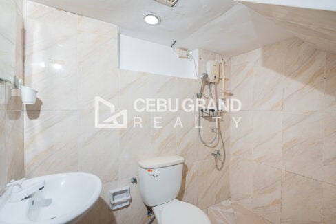 Bathroom with marble-look tiles, a hot-water shower and pedestal sink