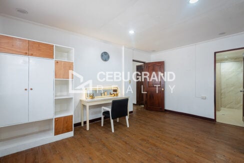 Bedroom with a white-and-wood wardrobe and a vanity desk under a lit mirror